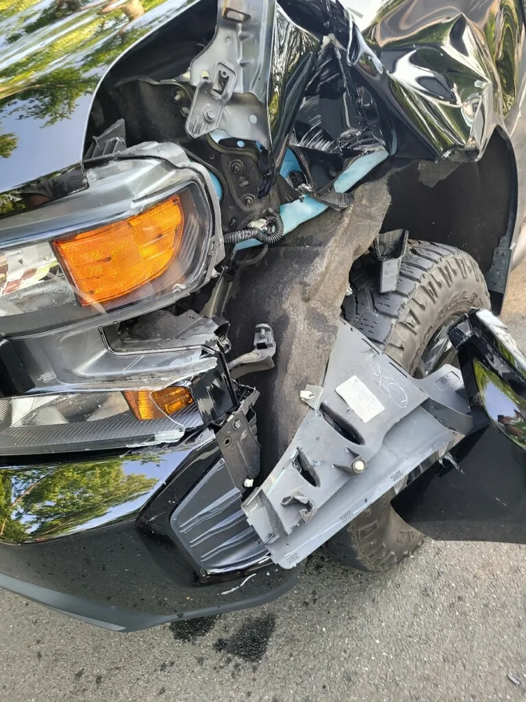 Black pickup truck with front-end collision damage