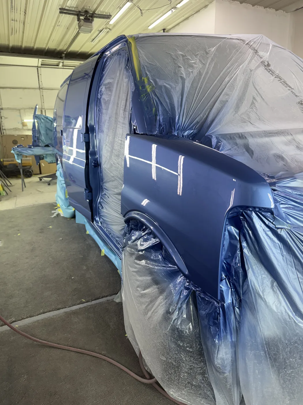 Blue van masked for paint work inside the shop