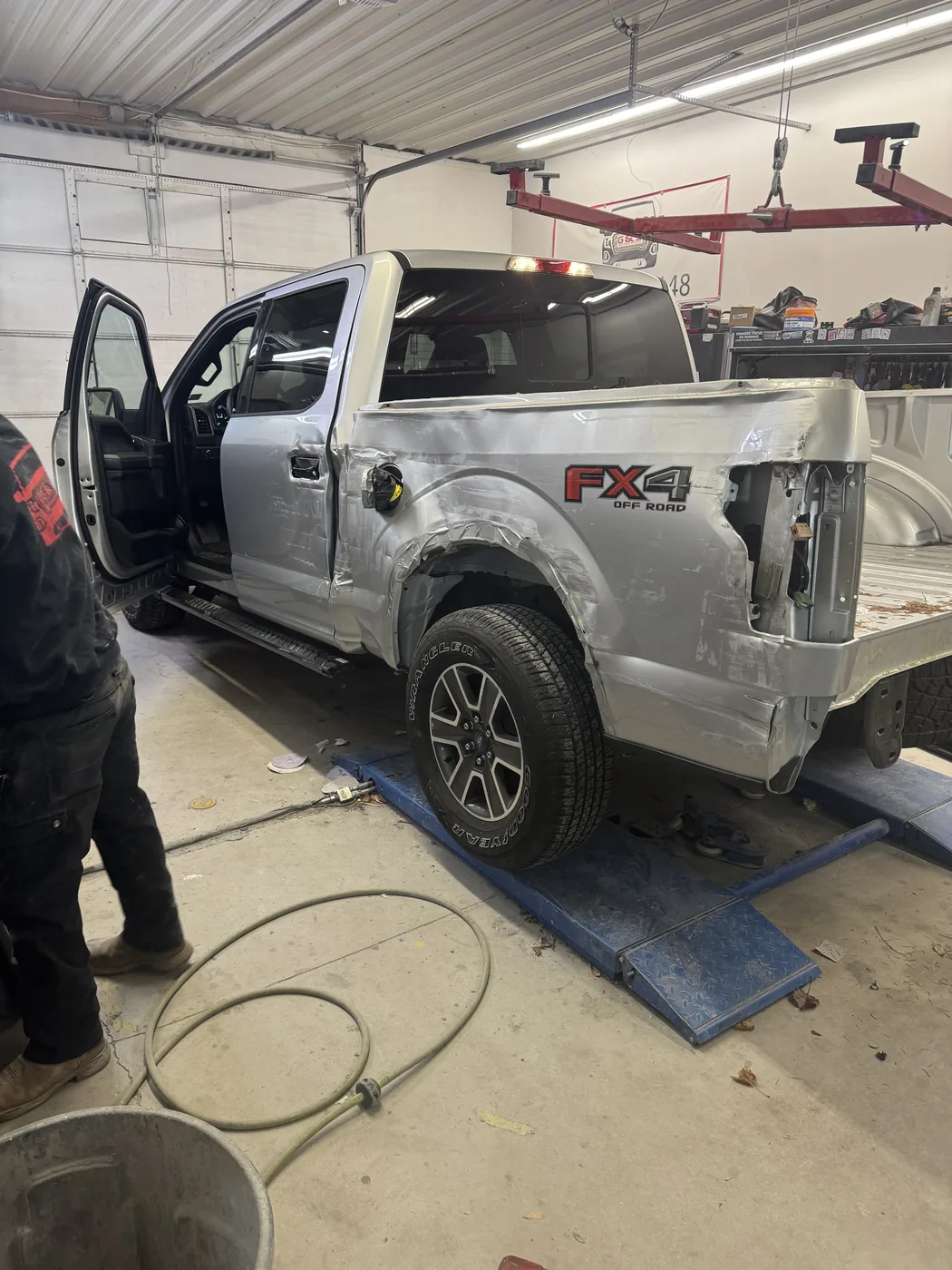 Silver pickup truck undergoing body repair
